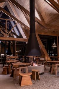 a lobby with wooden tables and a fire pit at Tawa Refugio del Puelo in Puelo