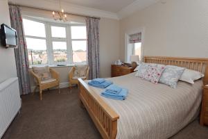 a bedroom with a bed with two towels on it at Camberley House in Sheringham