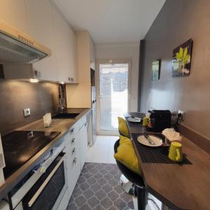 a kitchen with a counter and a yellow chair in it at Mélodie in Cannes