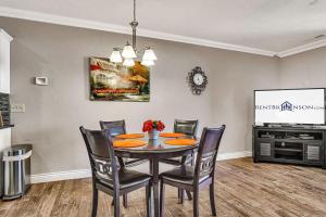 a dining room with a table and chairs and a tv at Hawthorne -- 1410 in Branson