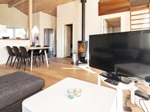 ein Wohnzimmer mit einem großen TV und einem Kamin in der Unterkunft 6 person holiday home in L kken in Løkken