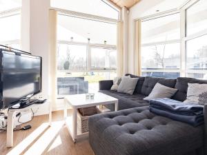 ein Wohnzimmer mit einem Sofa und einem TV in der Unterkunft 6 person holiday home in L kken in Løkken