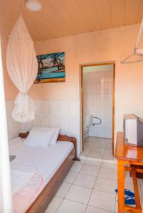 a small room with a bed and a bathroom at Auberge La Caverne in Kigali
