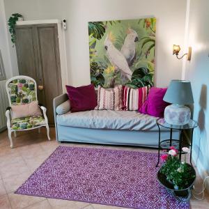 sala de estar con sofá azul y alfombra morada en Suite Eleven, en Castiglioncello
