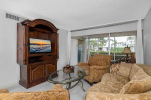 a living room with a tv and a couch and a table at Beach Luxury 805 in Naples