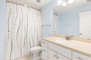 een badkamer met een toilet, een wastafel en een spiegel bij Village Place 6B - Bella Tybee in Tybee Island