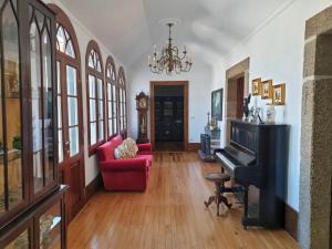 - un salon avec un canapé rouge et un piano dans l'établissement Casa do Terreiro, à Barqueiros
