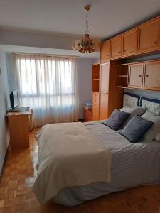 een slaapkamer met een groot bed en een raam bij Piso centro Luanco in Luanco