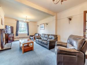 sala de estar con muebles de cuero y TV en Mulberry House en Highbridge