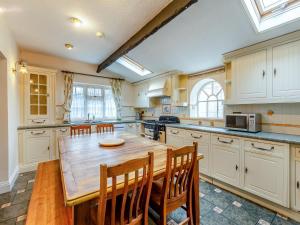 cocina grande con mesa de madera y sillas en Mulberry House, en Highbridge