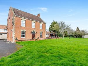 una gran casa de ladrillo con un patio verde en Mulberry House en Highbridge