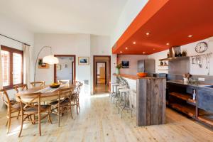 a kitchen and dining room with a wooden table and chairs at Lontananza in Sant Francesc Xavier