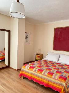 een slaapkamer met een groot bed met een kleurrijke deken bij Cozy Apartment near Ohrid Lake in Pogradec