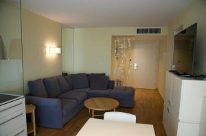 een woonkamer met een blauwe bank en een tafel bij Nikola Luxury Apartments Senia in Petrcane
