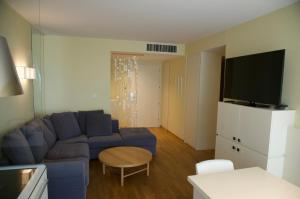 uma sala de estar com um sofá azul e uma televisão em Nikola Luxury Apartments Senia em Petrcane