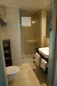 uma casa de banho com um chuveiro, um WC e um lavatório. em Nikola Luxury Apartments Senia em Petrcane