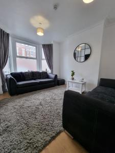 a living room with a couch and a mirror at 23 Woodhouse in Stoke on Trent
