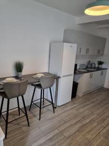 a kitchen with a table and chairs and a refrigerator at 23 Woodhouse in Stoke on Trent