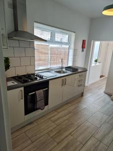 a kitchen with a sink and a stove top oven at 23 Woodhouse in Stoke on Trent