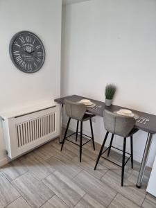 a dining room with a table and chairs and a clock at 23 Woodhouse in Stoke on Trent