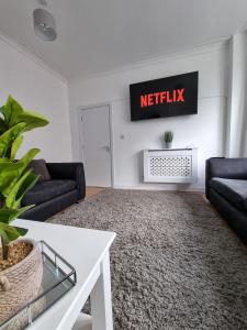 a living room with two couches and ametix sign on the wall at 23 Woodhouse in Stoke on Trent
