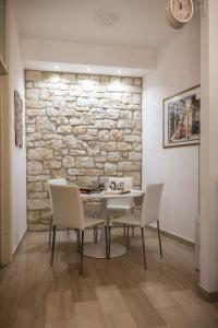 アッシジにあるApartment Assisi Cattedraleの石壁のダイニングルーム(テーブル、椅子付)