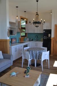 cocina y sala de estar con mesa y sillas en Cabañas Krause Lodge, en Puerto Varas