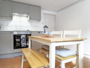 a kitchen with a wooden table and chairs at June Cottage in Bognor Regis