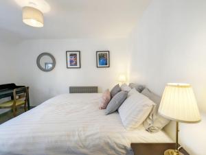a bedroom with a large white bed with pillows at June Cottage in Bognor Regis