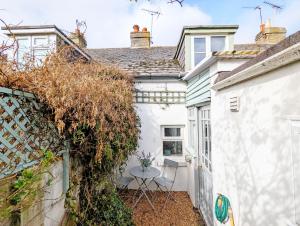 a small white house with a table in the courtyard at June Cottage in Bognor Regis