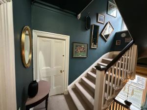 a hallway with a staircase with a blue wall at 1869 - Room Only Boutique Townhouse in Ambleside