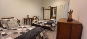 een slaapkamer met 2 bedden, een dressoir en een spiegel bij Casa Galante in Furnas