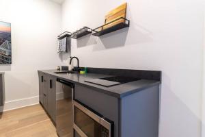 a kitchen with a black counter and a sink at Thena Hotel- Lux Studio in Philadelphia