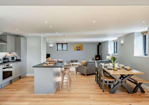 a kitchen and living room with a table and a couch at The Oat Barn in Hawkedon