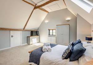 a bedroom with a large bed with two towels at The Oat Barn in Hawkedon