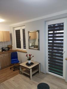 a living room with a table and a blue chair at Apartament przy dworcu in Krosno