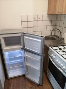 a kitchen with an open refrigerator and a stove at Apartament przy dworcu in Krosno
