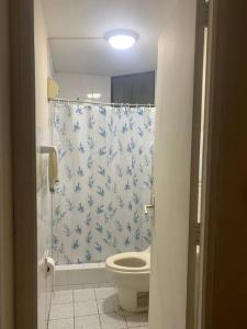 łazienka z toaletą i niebiesko-białą zasłoną prysznicową w obiekcie Departamento Privado w mieście Lima