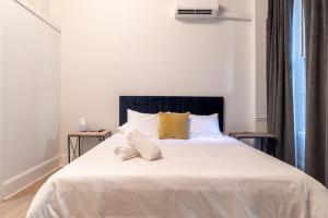 Un dormitorio con una gran cama blanca con dos almohadas. en Thena Hotel - Ground Floor 1 Bedroom Suite, en Filadelfia 18 fotos más