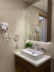 a bathroom with a white sink and a mirror at Căn hộ 5 sao tiêu chuẩn Quốc Tế rộng 95m2 ở Aria Resort Vũng Tàu in Xa Thang Nhut