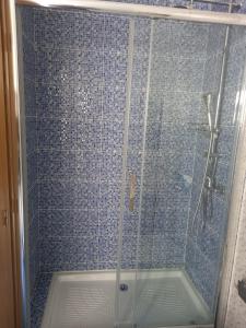 La salle de bains est pourvue d'une douche avec une porte en verre. dans l'établissement CityInn Suites, à Lisbonne