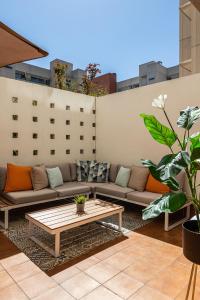 a patio with a couch and a coffee table at BNBHolder Terrace, Pool & Gym LAS TABLAS in Madrid