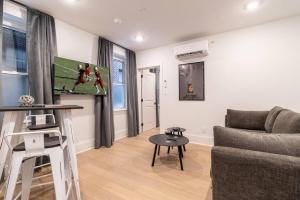 费城Thena Hotel - Oversized 1 Bedroom的客厅里有一张沙发和一张桌子。