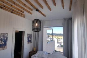 1 dormitorio con luz colgante y ventana en למרגלות הגלבוע, en Gid‘ona