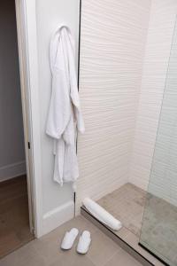 费城Thena Hotel - Oversized 1 Bedroom的带淋浴、白色毛巾和拖鞋的浴室