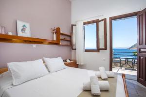a bedroom with a bed with a view of the ocean at Margaritas apartments in Symi