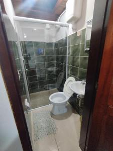 a bathroom with a shower and a toilet and a sink at Pousada Taquinha Paraty in Paraty