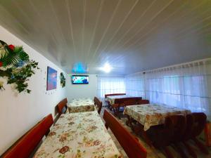 a room with two tables and chairs and a tv at Casa cu flori in Tuzla