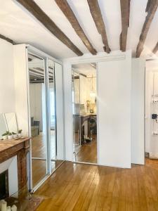 un soggiorno a pianta aperta con pareti bianche e pavimenti in legno di Electra mini-studio a Parigi
