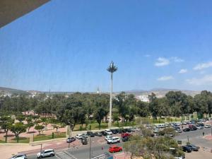 een parkeerplaats met een palmboom op een parkeerplaats bij Cosy appartement au super centre ville avec vue partielle sur le parc in Agadir